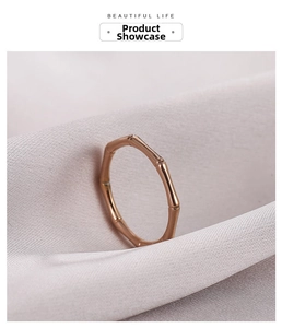 Macro shot of rose gold bamboo-style ring on elegant purple satin fabric texture