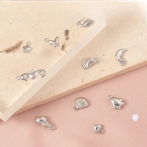 Macro view of polished silver charms featuring mermaid, seahorse, and shell motifs