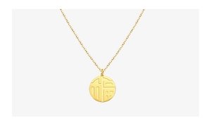 Detail shot of a round gold pendant engraved with the Chinese Fu character on a fine chain