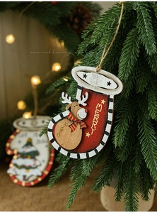 Detail of wooden Christmas ornaments with reindeer and snowflakes hanging on a festive tree