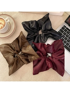 Three large square scrunchies in black, brown, and burgundy with pleated faux leather texture
