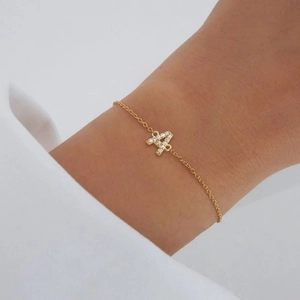 Close-up of golden letter A pendant with micro-pave cubic zirconia on a minimalist chain
