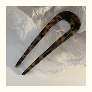 Close-up of tortoise shell U-shaped hairpin with France Handmade text on white paper