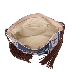 Interior details of bohemian woven tote showing lining, zipper pocket, and fringe decor