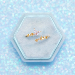 Macro shot of gold butterfly and flower ring with crystals in a blue velvet box