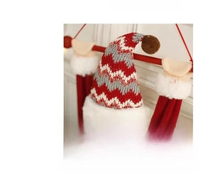Close-up of a knitted Christmas hat with red white and grey wave patterns and fur trim