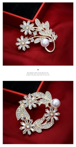 Detailed view of luxury gold floral brooch with crystals and pearls on red velvet