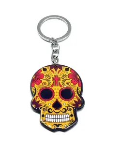 Detailed close-up of a vibrant acrylic sugar skull keychain with floral Mexican folk art