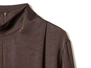 Détail d'une robe en satin à col montant avec tissu marron et fermeture éclair YKK
