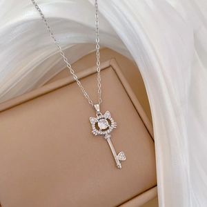 Macro shot of silver cat-ear key pendant necklace with sparkling zircon pavé setting