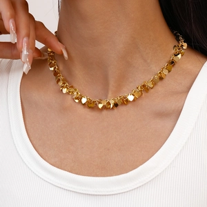 Golden heart fringe necklace with minimalist sequins shown on a model neck