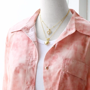 Detail of elegant gold double-layered heart pendant necklace shown on a model