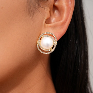 Close-up of elegant gold stud earring featuring a large white pearl and crystal rhinestones