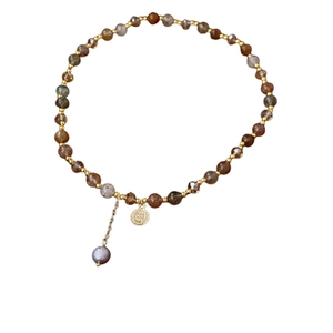 Multilayer beaded bracelet featuring natural stones, gold charms and a grey pearl accent