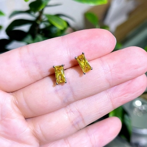 Detail of yellow rectangular zircon earrings with silver four-prong setting