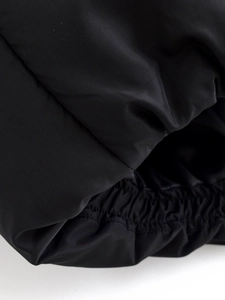 Detail of black technical fabric showing elastic cuff structure and fine stitching