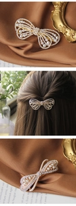Detailed view of a gold bow hair clip with sparkling rhinestones and elegant pearls