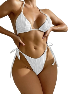 Dettaglio della texture a coste del bikini bianco con lacci laterali e scollo a halter