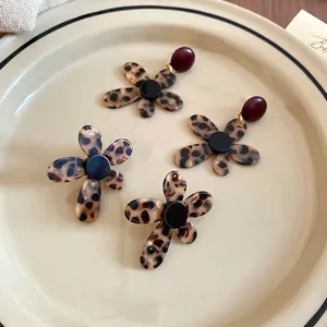 Vintage leopard acetate flower drop earrings with tortoiseshell texture on ceramic plate