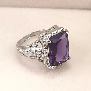 Detail view of large rectangular purple zircon gemstone with intricate vintage hollow carving
