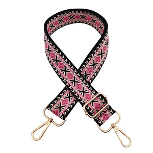 Close-up of geometric diamond weave bag strap with golden metal swivel hooks