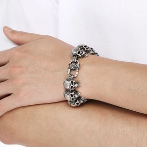 Detail of silver skull chain bracelet with cross clasp on wrist for a dark gothic style