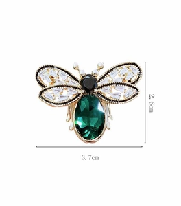 Detail view of crystal bee brooch measuring 2.6cm by 3.7cm with green oval stone