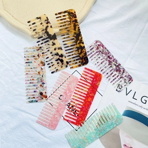 Flat lay of marble texture acetate hair combs in various colors on white cloth