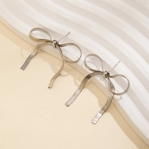 Detailed macro view of silver bow stud earrings made from sleek metal snake chains