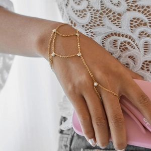 Vue détaillée du bracelet bague élégant en or avec zircons brillants sur la main d'un modèle