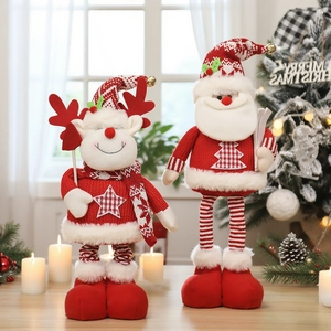 Standing knitted Christmas Santa and reindeer plush figures on table with festive tree background