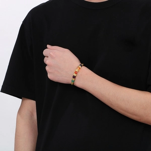 Dettaglio di perle in pietra naturale colorate e distanziatori dorati su bracciale in cuoio