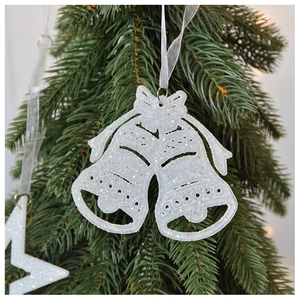 Close-up of white glitter bell ornaments hanging on a festive Christmas tree
