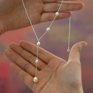 Detailed view of elegant silver Y-shaped necklace with six teardrop freshwater pearls