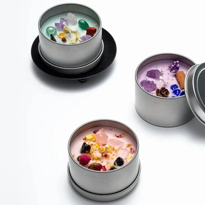 Three crystal scented candles in silver tin jars with dried flowers and gemstones