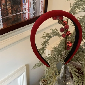 Détail d'un serre-tête en velours rouge avec baies et clochettes sur décor de fête