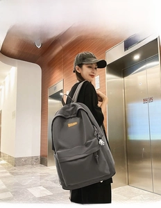 Deep gray large capacity backpack featuring front zipper pocket and side charm for students