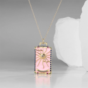 Macro shot of gold sun tarot pendant necklace featuring colorful crystals and pink enamel