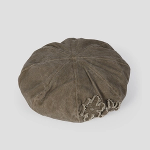 Close-up of vintage washed cotton beret with stitched flower applique and rustic texture