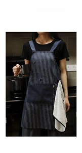 Close-up of striped denim apron with large front pocket and side towel loop detail