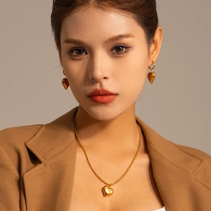 Classic 18k gold plated heart pendant necklace and earrings set on a model