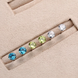 Detail view of colorful round zircon stud earrings in blue green and white silver settings
