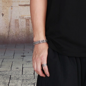Detail shot of men's silver stainless steel woven chain bracelet and matching ring set