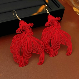 Détail macro des boucles d'oreilles poisson rouge avec textures découpées et crochets dorés