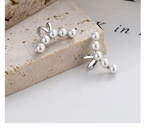 Close-up of five white pearls arranged in an arc on a 925 silver non-piercing ear cuff