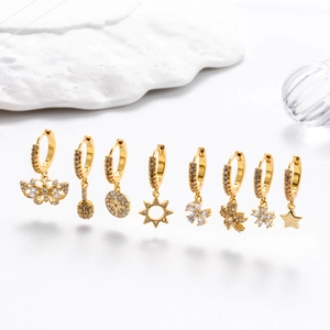 Set of eight gold earrings featuring sparkling zircon pendants in butterfly and star shapes