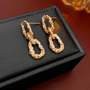 Textured gold double link chain earrings on a black leather jewelry display