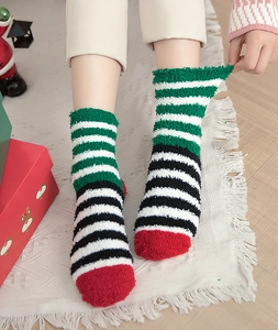 Detail of plush coral fleece striped socks showing warm texture in a festive Christmas setting