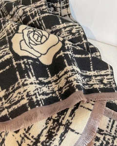 Detailed close-up of camellia pattern and fringe edge on thick knitted scarf shawl