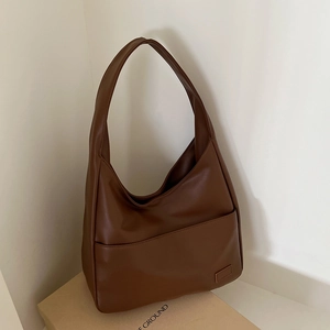 Detailansicht der braunen Hobo-Tasche aus PU-Leder mit breitem Gurt und Fronttasche